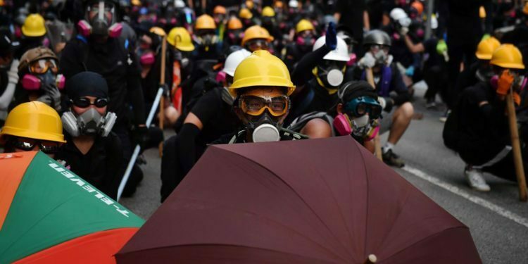 מפגינים עם מטריות ומסכות אב"כ מתעמתים עם משטרת ההפגנות במפרץ קאולון, הונג קונג, 24 באוגוסט, 2019 (ליליאן סוואנרומפה / AFP / גטי אימג'ז)