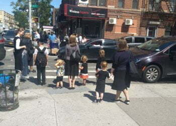 נשים וילדים מחכים ליד מעבר חצייה בשכונת בורו פארק שבברוקלין, 3 בספטמבר, 2019 (בן סלס)