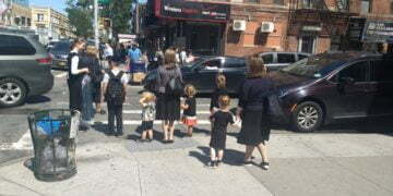 נשים וילדים מחכים ליד מעבר חצייה בשכונת בורו פארק שבברוקלין, 3 בספטמבר, 2019 (בן סלס)